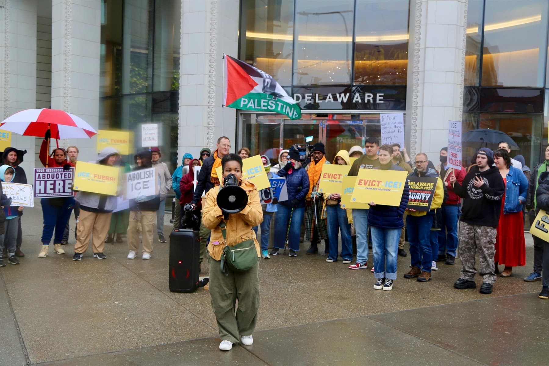 Demonstrators gather outside 250 Delaware Avenue as a speaker addresses the crowd with a megaphone