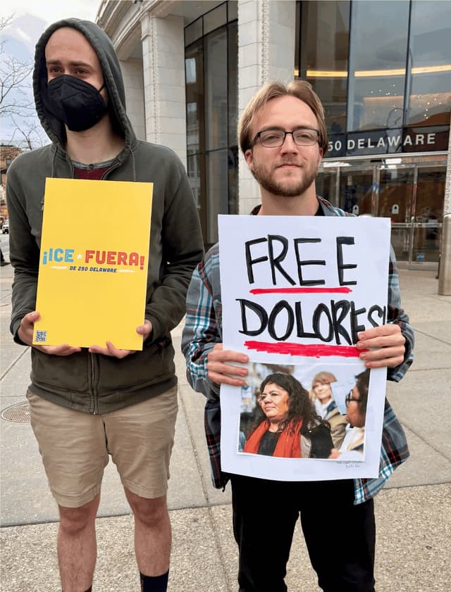 Demonstrators holding '¡ICE Fuera!' and 'Free Dolores' signs outside 250 Delaware