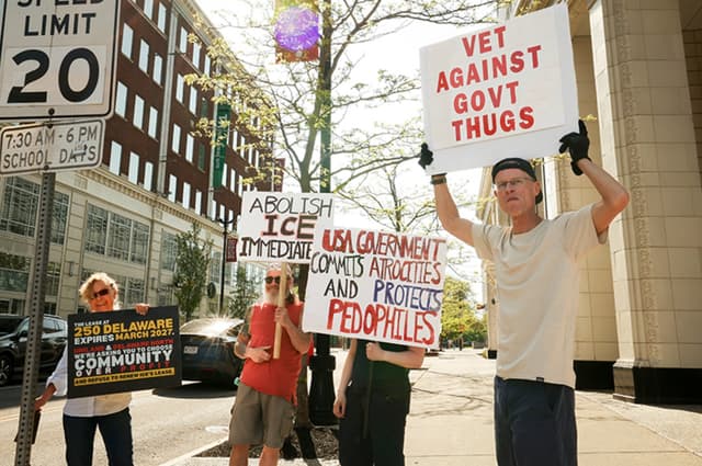Demonstrators on the street holding 'Abolish ICE' signs